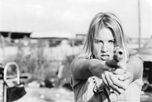 Renee Zellweger aims a gun in Love and a .45 (1994)