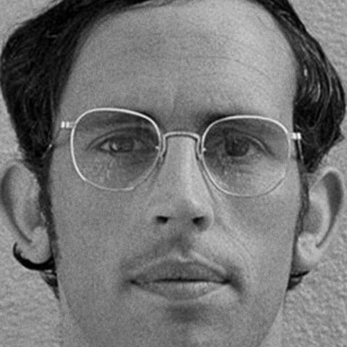 a tight black and white closeup of a man staring into the camera. a head, if you will